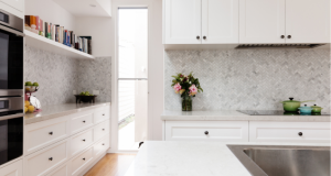 A new kitchen with marble splashbacks and drawers with black handles. This new kitchen was added to an investment property after an older 90s kitchen was removed. There was residual value in that older kitchen.