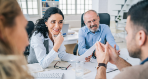 Two accountants sit at a desk with their two clients discussing their Depreciation Schedule.