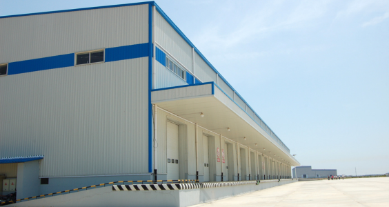 A warehouse with blue trim and a large loading yard has significant concrete loading docks and a driveway shared by each of the owners. Each owner is entitled to claim depreciation on their share of this driveway, as well as their loading docks.