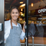 A cafe owner opens the door to their cafe, welcoming guests in. The owner of the property can claim depreciation on the building and the fixed assets of the property.