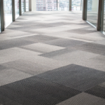 Grey carpet in a herringbone pattern in an office hallway. Carpet is an example of an Asset that can be claimed second hand in Commercial property, but cannot be claimed in a Residential property.