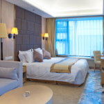 A hotel room with a bed, sofa and coffee table. It is possible to purchase hotel rooms and depreciate them at 4% per year because of the additional wear and tear on the building.