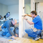 Two builders repairing the flooring of an older property getting it ready for rental. This would be classed as an initial repair because they are making the property better than when it was purchased. This expense will need to be depreciated.